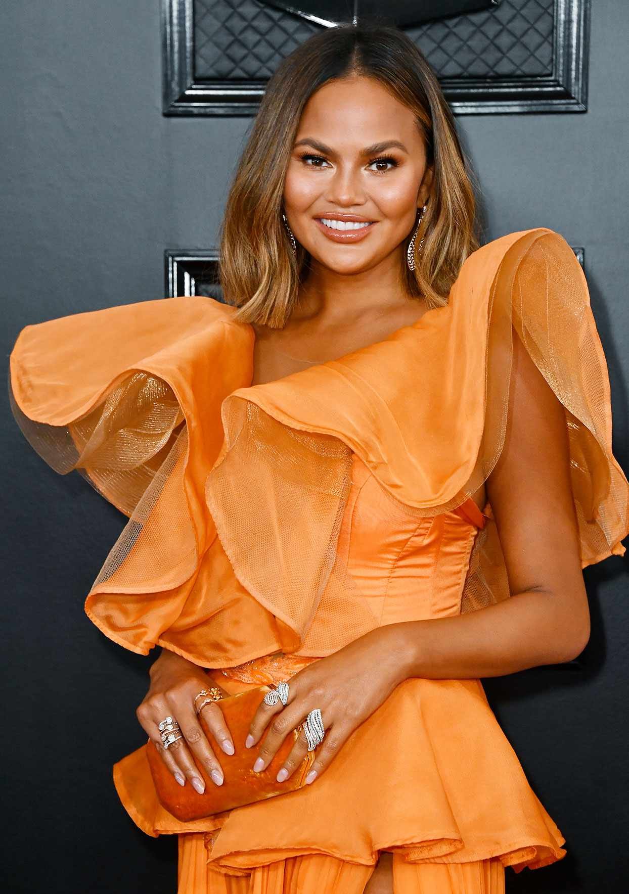 chrissy teigen with ombre high spot in orange ruffle dress