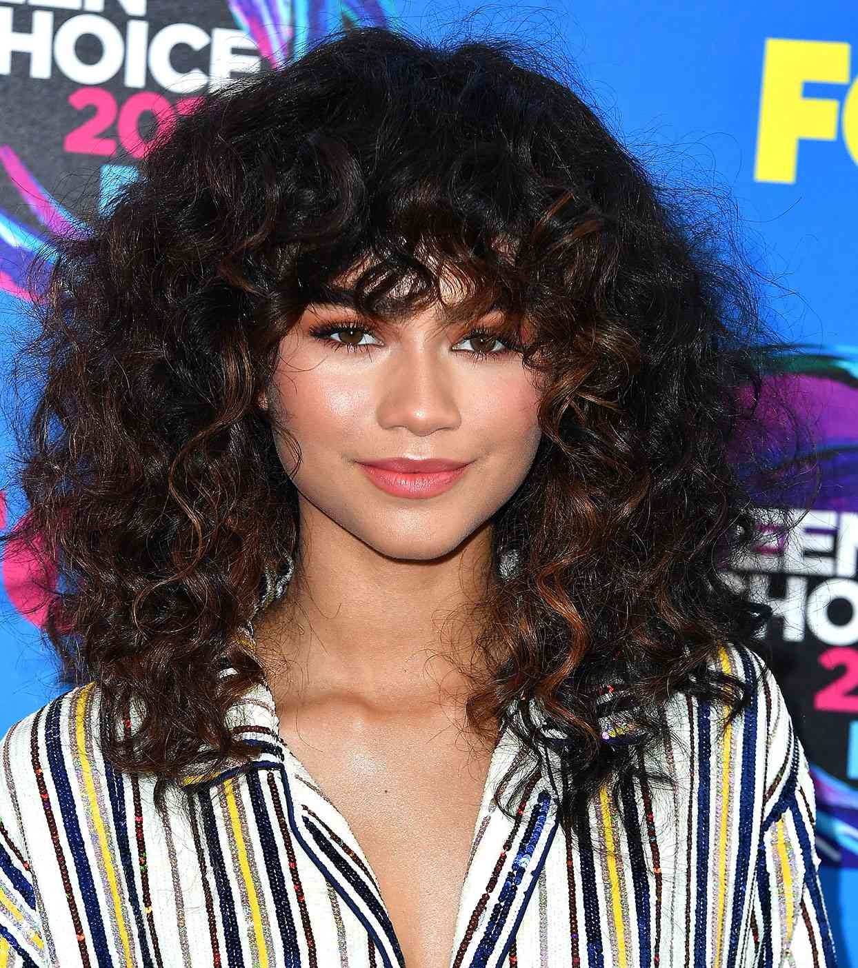 zendaya with curly hair and red highlights