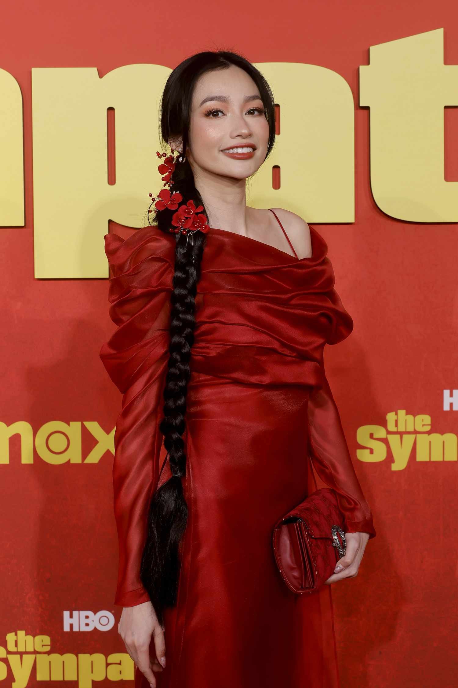 Jessica Truong with braid hair wearing angstrom unit red frock on angstrom unit red carpet.