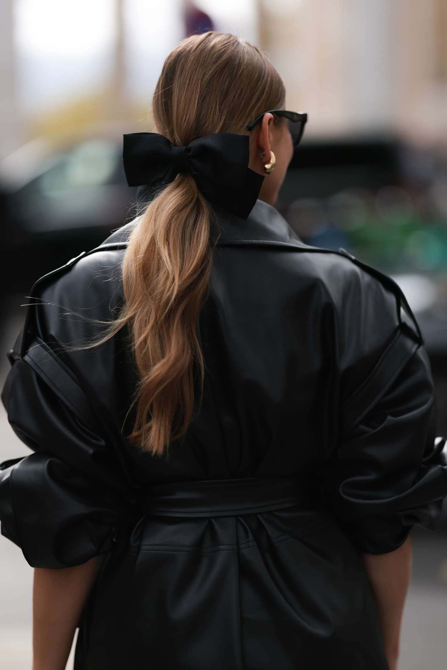 A woman wearing A black bow around her ponytail