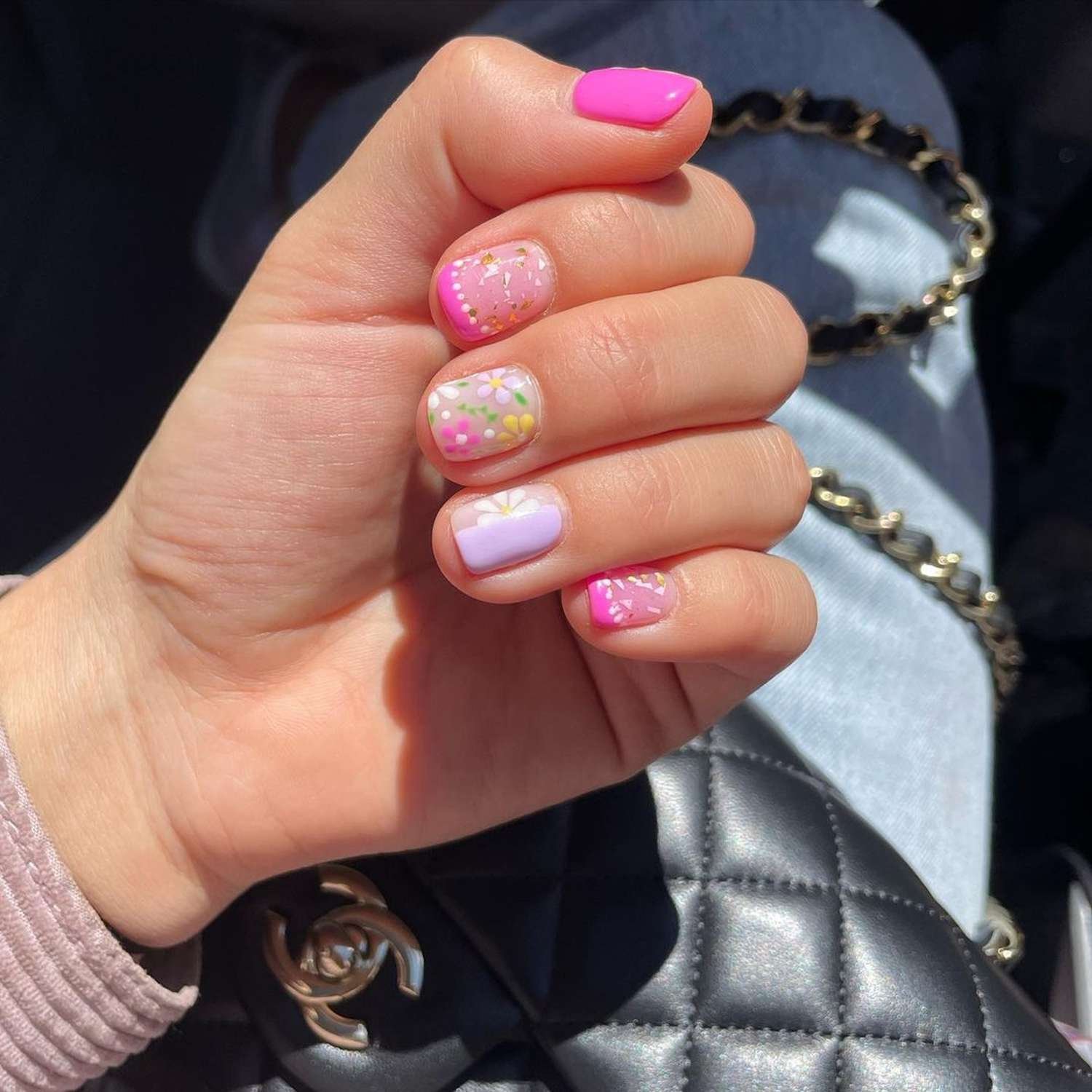 Short nail paint with hot pink, white, purple, and yellow polish in A springtime design