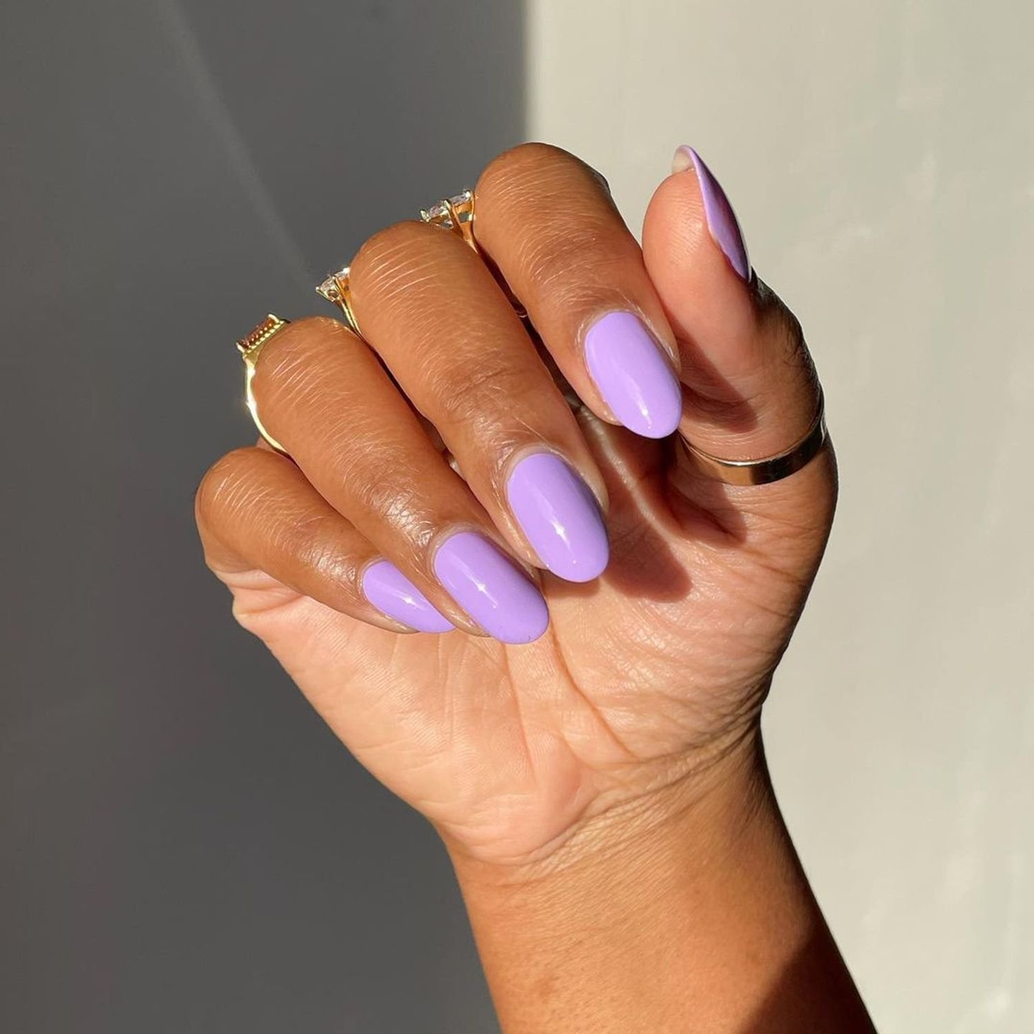 Hand with oval-shaped nails painted in lavender cream polish