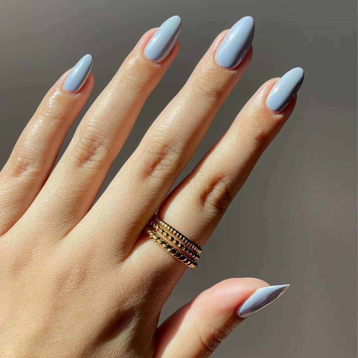 Nails painted with a dusty blue polish