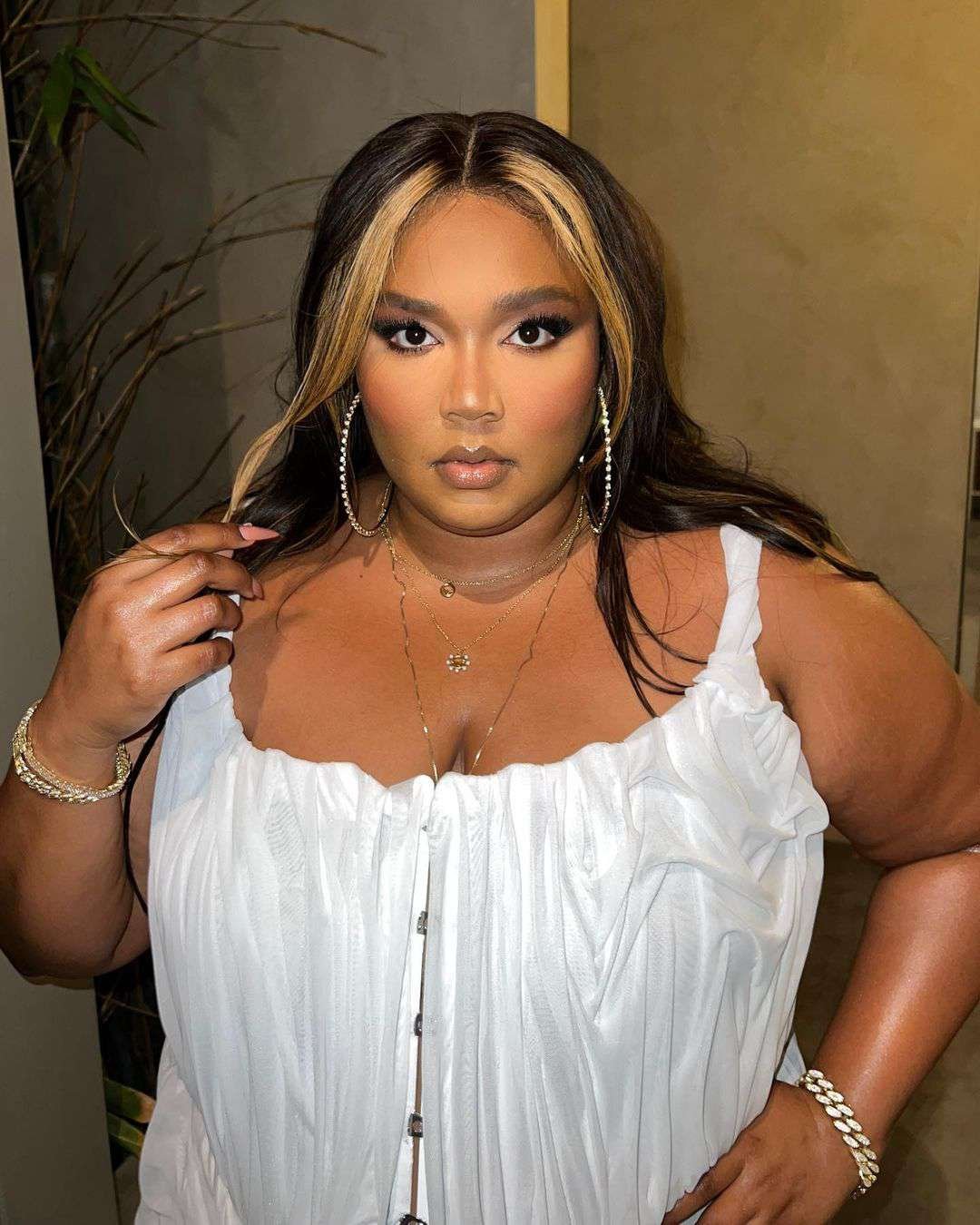 Lizzo in a White dress with a blond money piece highlight
