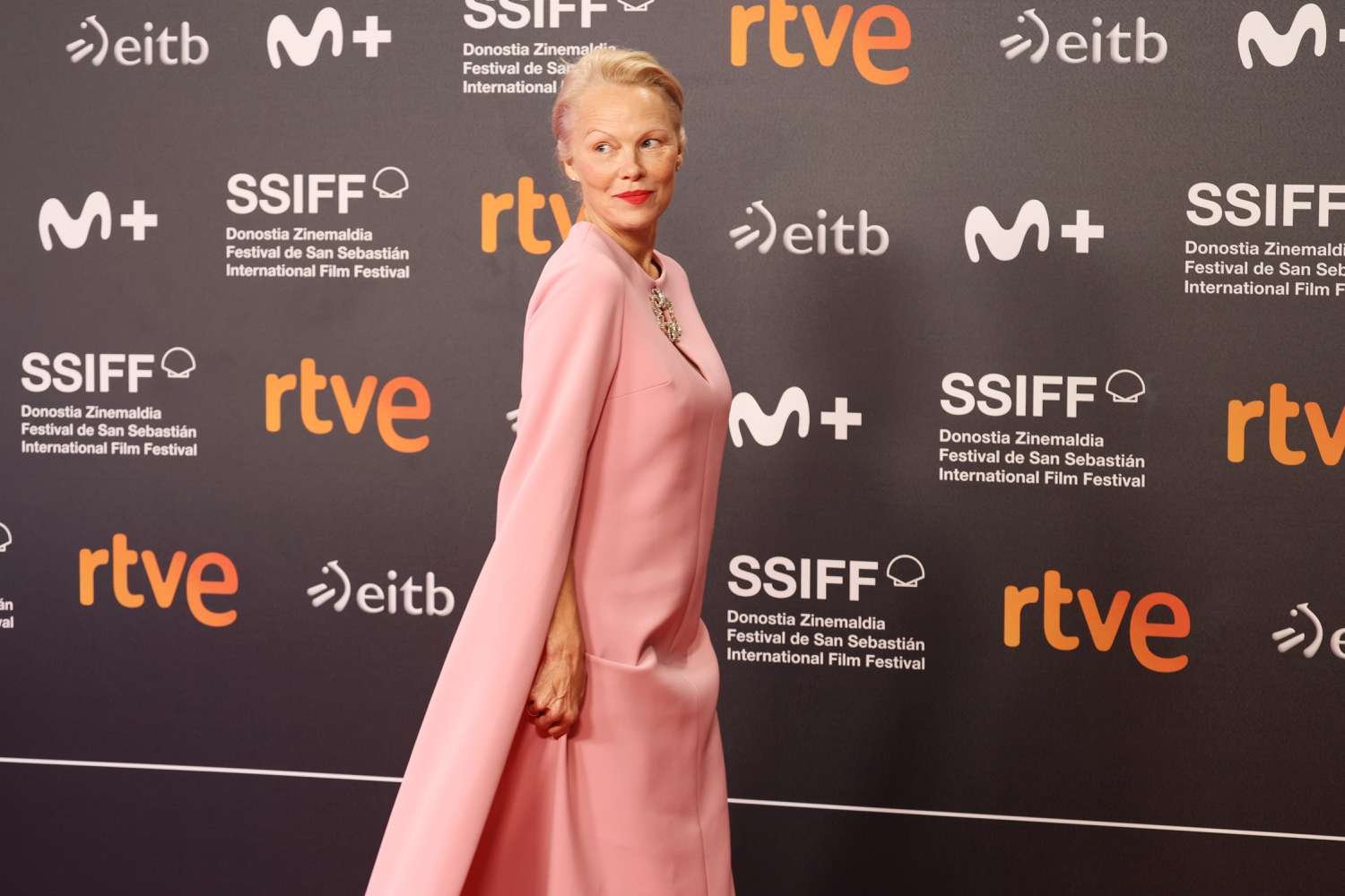 Pamela Anderson Soft grin Pink frock Red Lip walk on redness carpeting for 'The close Showgirl' at the 2024 San Sebastian Film Festival