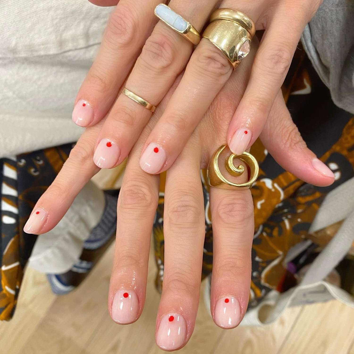 close up of nail with light pink manicure with 1 redness tiny dot on each nail