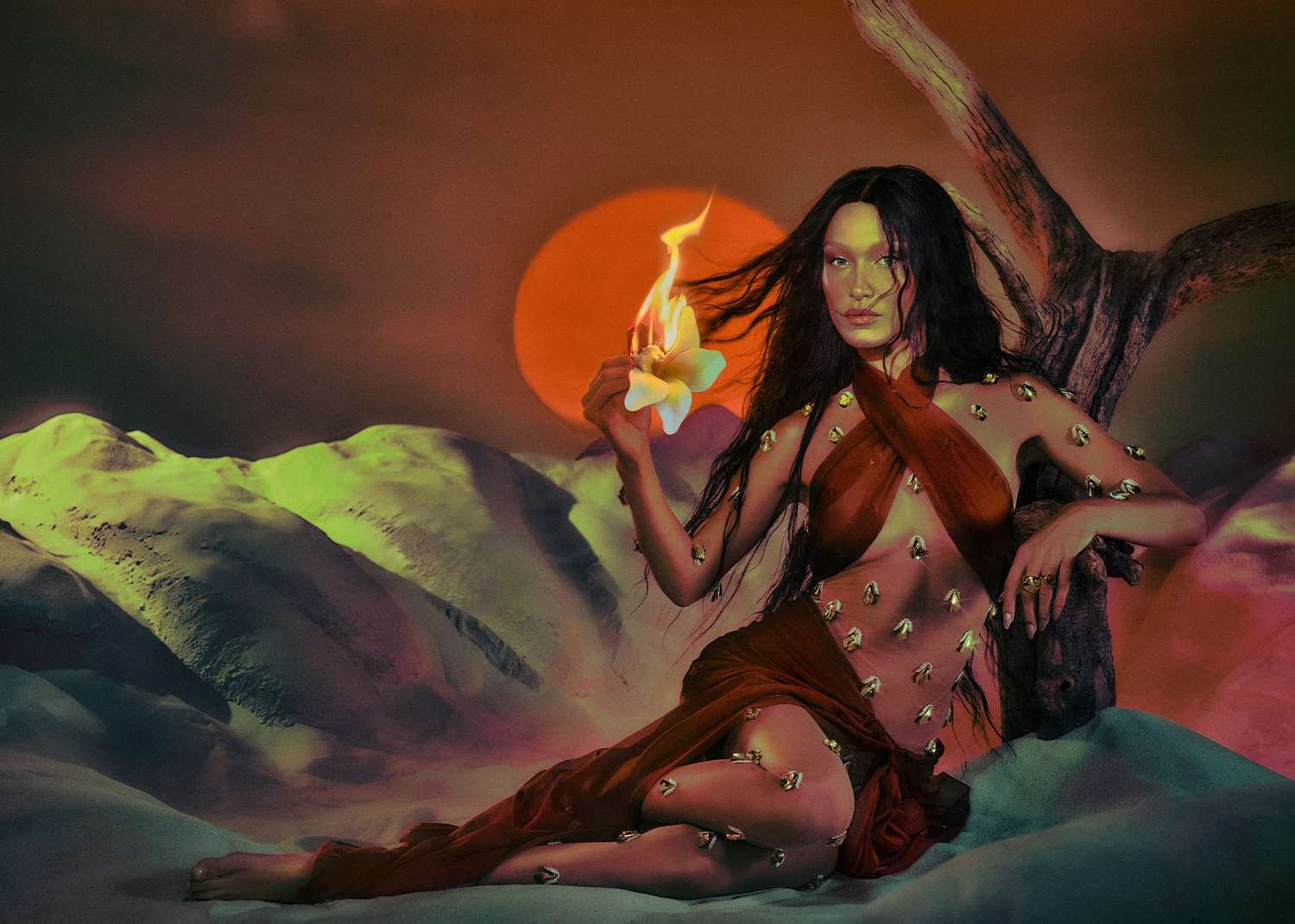 Bella Hadid posing with a flower that is on fire.