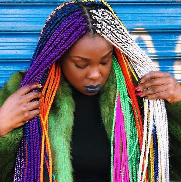 A person with hanker rainbow-colored box braids