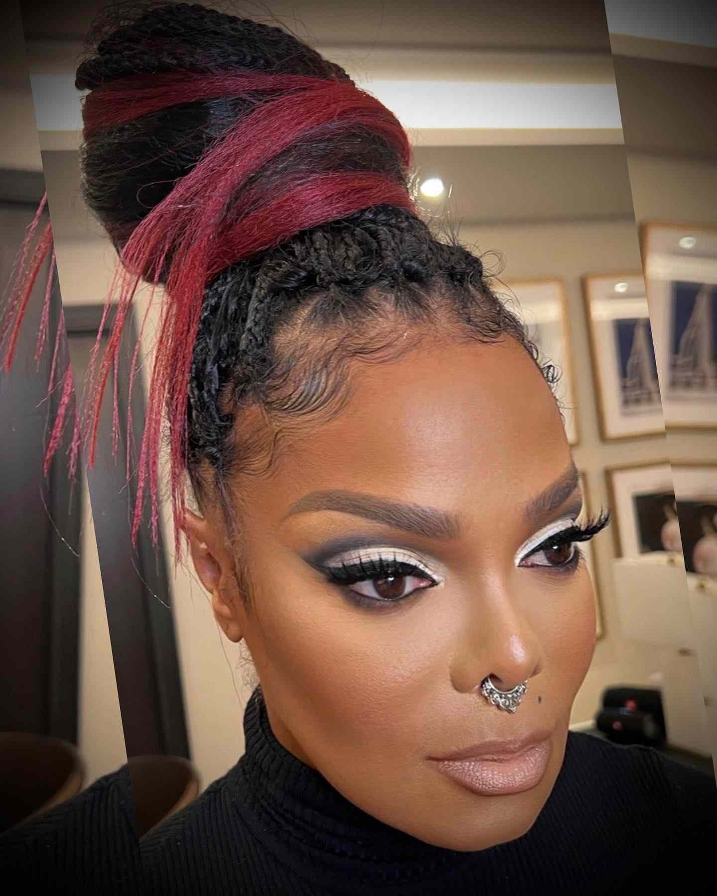 Janet Jackson wearing away a black-and-red top bun with slicked-down baby hairs